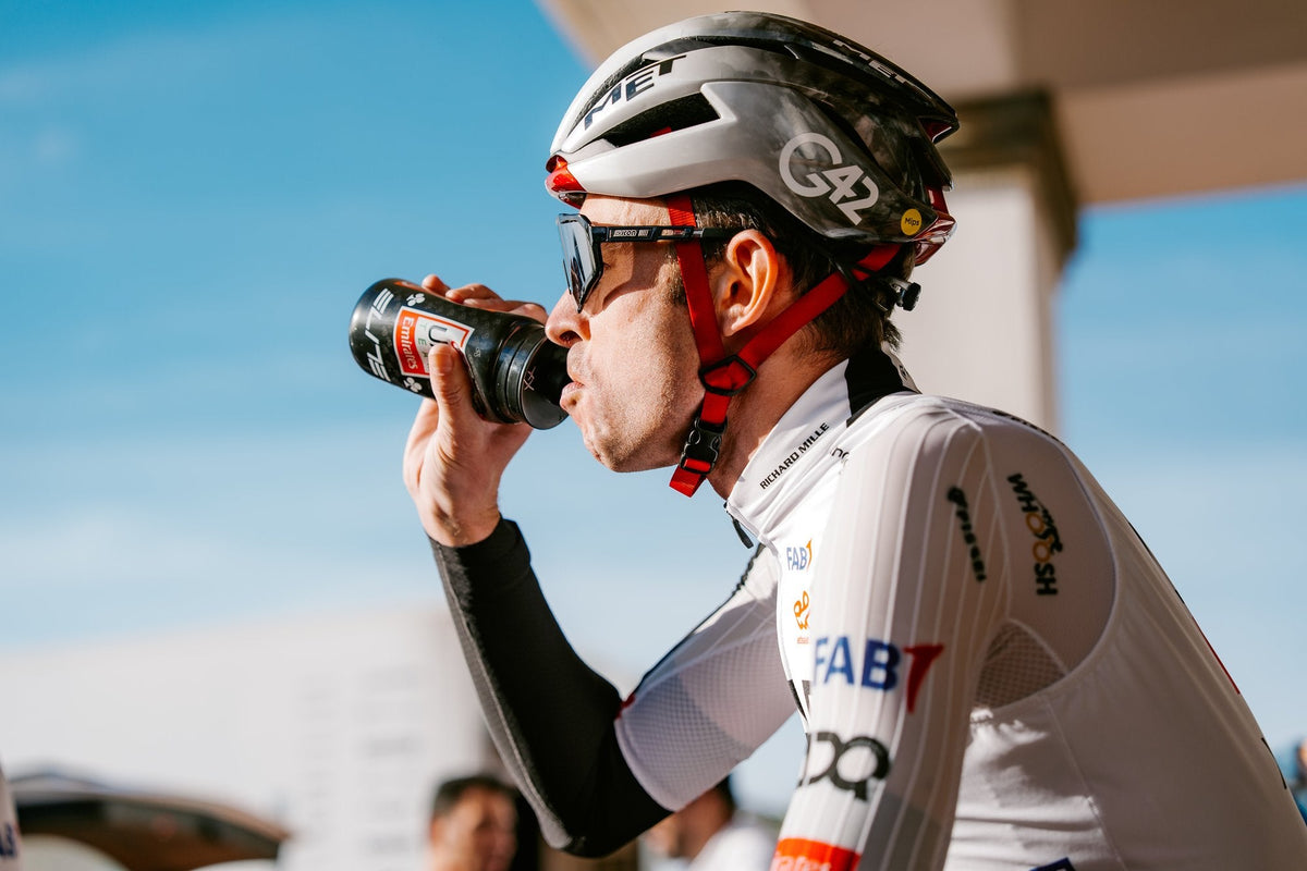 Cyklista UAE Team Emirates XRG pije z fľaše pred tréningom