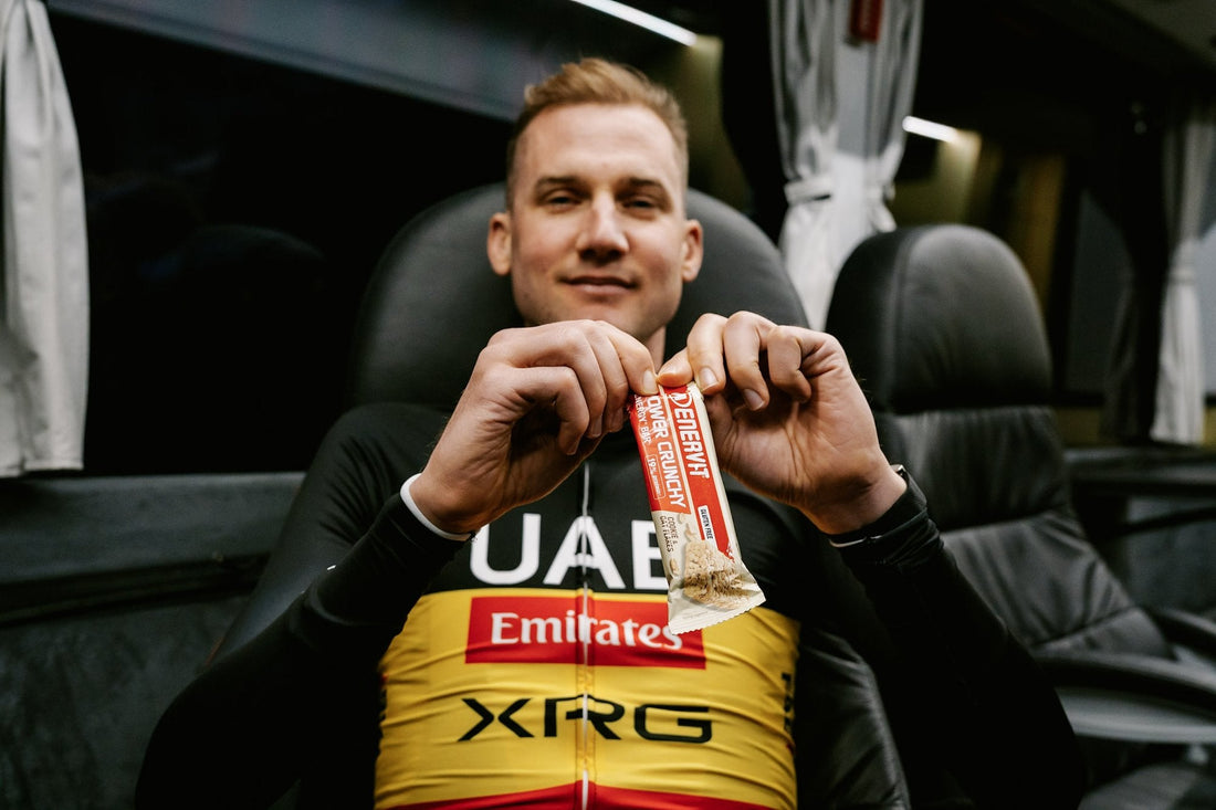 Cyklista UAE Team Emirates XRG s tyčinkou ENERVIT Power Crunchy v tímovom autobuse