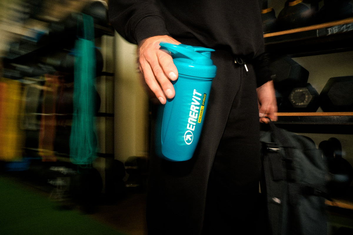 ENERVIT Shaker Reforce 700 ml v ruke športovca